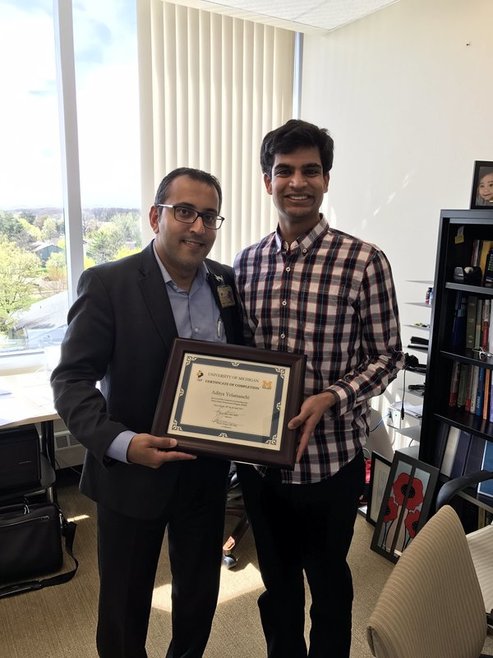 Dr. Chopra presents a certificate of completion to U of M student Aditya Yelamanchi. April 25, 2017.